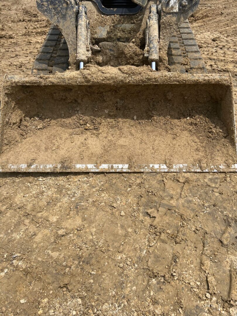 Before image of a dirty, soil impacted construction bucket.