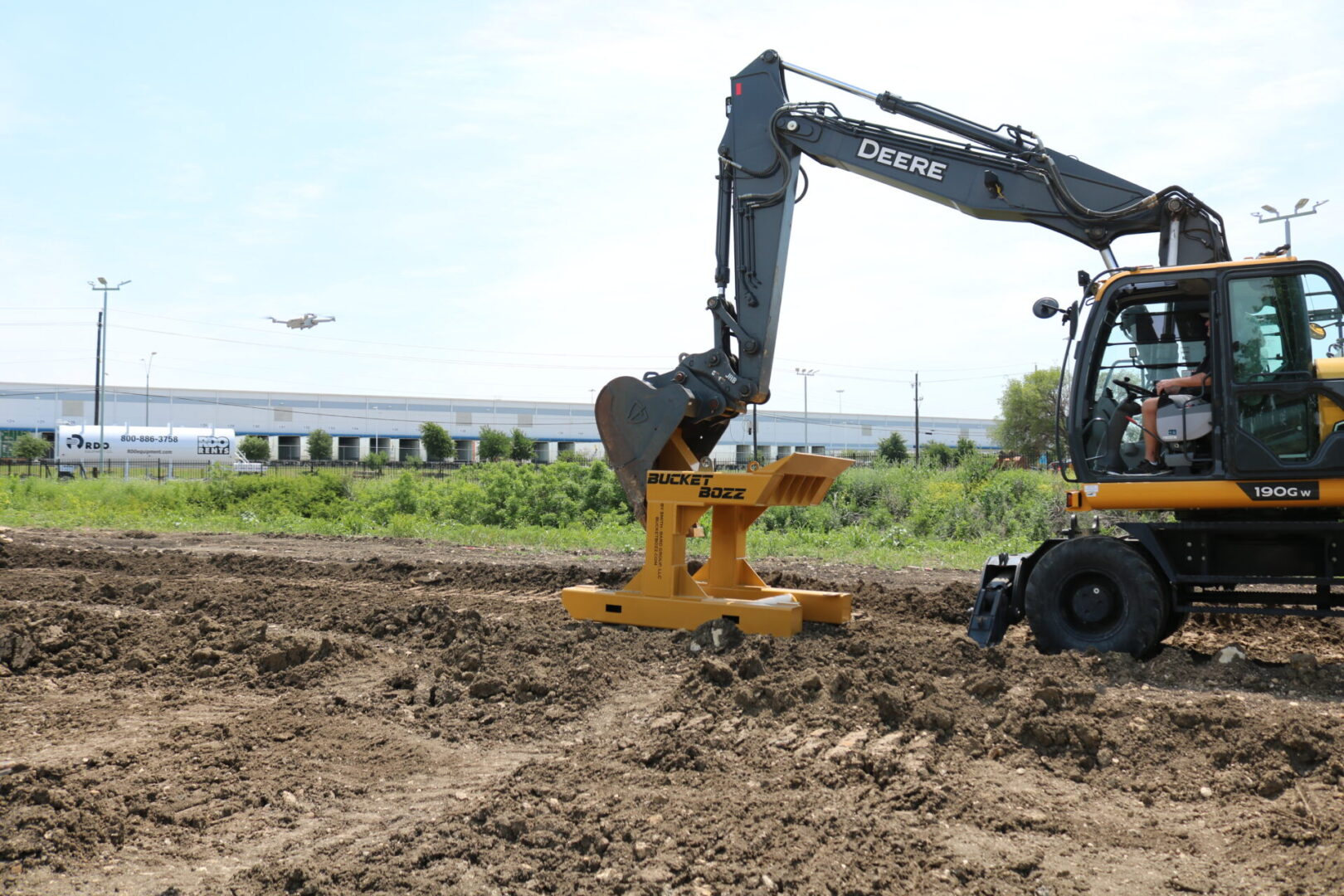 Large excavator using Bucket Bozz Cleaning Tool