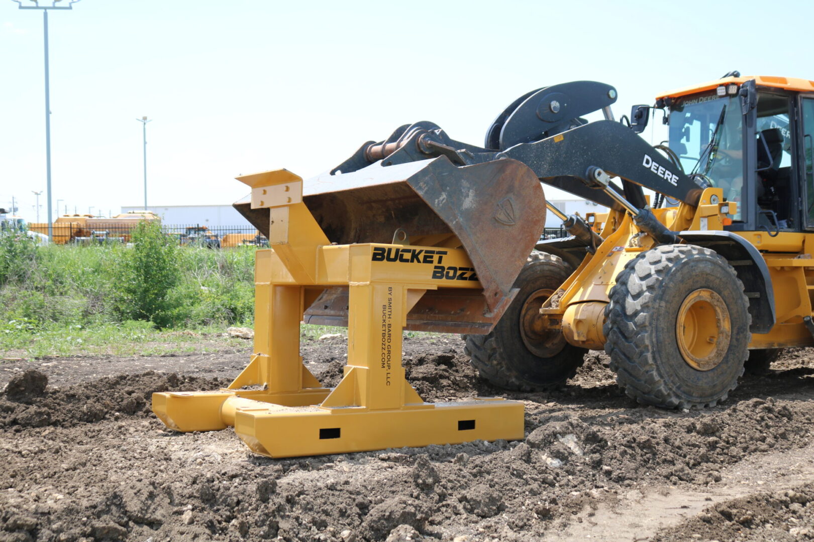 Side View of a Large Loader Bucket making contact with Bucket Bozz Hard Mount Cleaning Tool