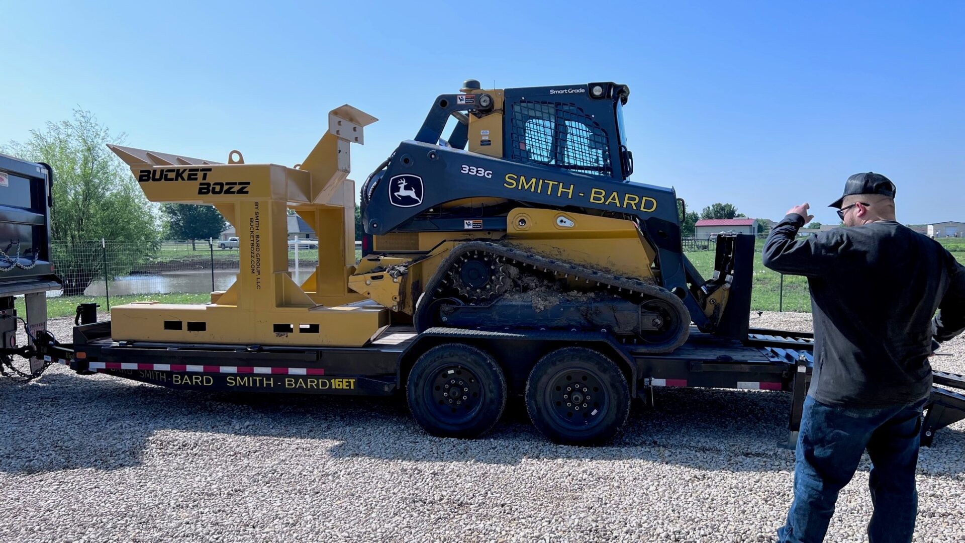 Bucket Cleaning System Loaded on a transportation trailer with a Compact Track Loader